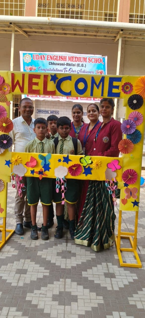 Teachers and students beneath a decorated welcome arch congratulating the school's achievers