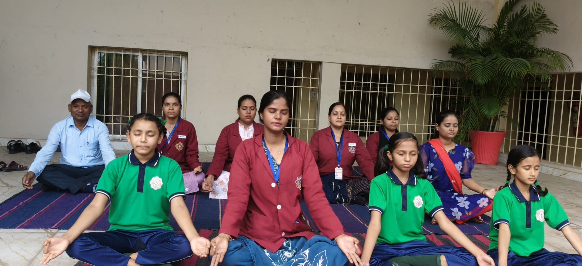 Students and teachers meditating cross-legged during a wellness session